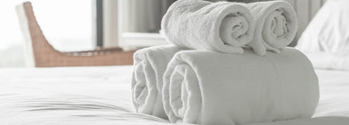 white folded tidy towels on bed